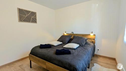 a bedroom with a bed with two pillows on it at Le Refuge de Coccinette in Essey