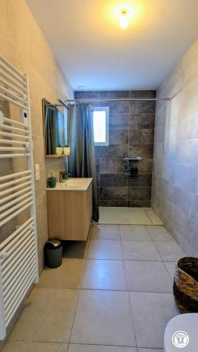 a bathroom with a tub and a sink and a shower at Le Refuge de Coccinette in Essey
