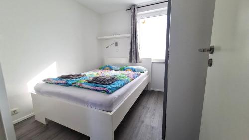 a small bed in a room with a window at PONTUS Ferienwohnung FeWo 1 in Zislow