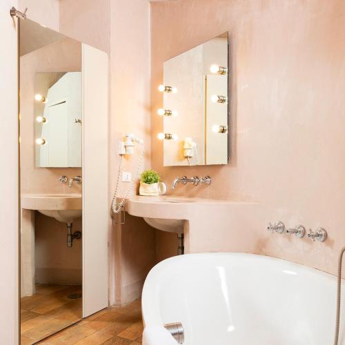 a bathroom with a sink and a toilet and a mirror at Baia delle Rocce Verdi Resort in Naples
