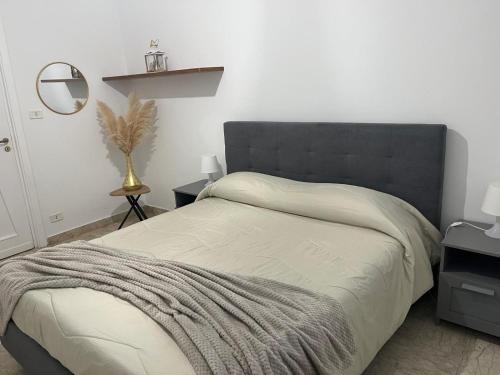 a bedroom with a large bed with a black headboard at Appartamento in villa in Torre a Mare
