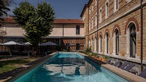 ein Swimmingpool in einem Hof neben einem Gebäude in der Unterkunft Fourvière Hôtel in Lyon