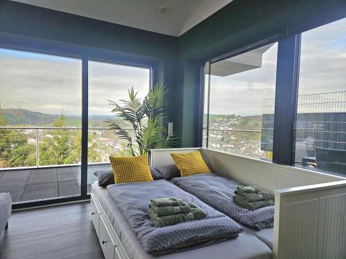 a couch in a living room with a large window at Luxus-Penthouse mit einzigartigem Schlossblick in Bad Berleburg
