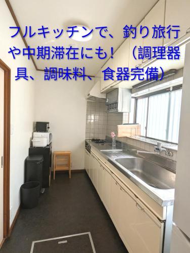 a kitchen with blue writing on the wall at Apt南熱海-網代 in Atami