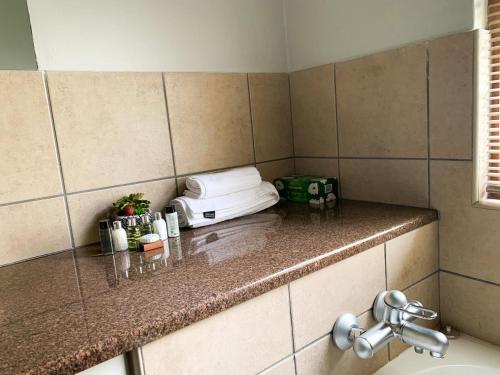 a bathroom with a counter top with a sink and a sink at Lekoa Lifestyle Apartment in Vanderbijlpark