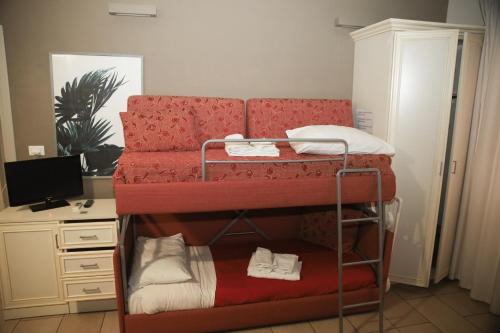a room with two bunk beds and a desk at Le Plejadi in Castellammare del Golfo