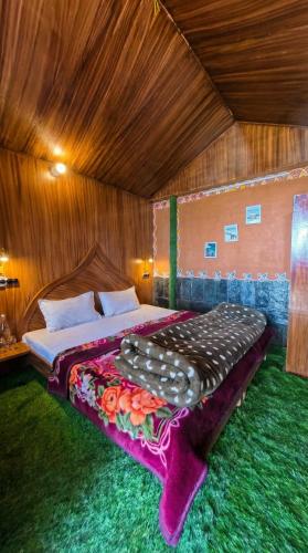 a bedroom with a large bed in a room at Mhara Himachal in Bīr