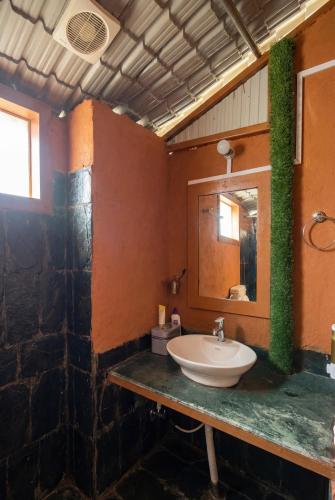 a bathroom with a sink and a mirror at Mhara Himachal in Bīr
