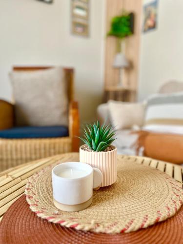 a coffee table with a cup and a plant on it at Le Refuge du Mans in Le Mans