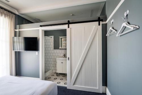 eine Schiebetür zur Scheune in einem Schlafzimmer mit Bad in der Unterkunft The North Sydney Hotel in Sydney