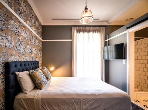a bedroom with a bed and a window and a television at The North Sydney Hotel in Sydney