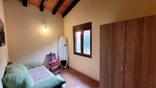 a room with a surfboard in the corner of a room at La Casuca in Celucos