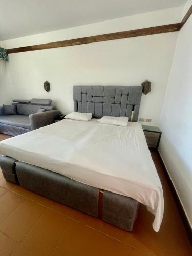 a bedroom with a large bed and a couch at Private one-unit in Domina coral bay Beach and lake direct view 3 in Sharm El Sheikh