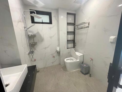 a white bathroom with a toilet and a sink at CH home apartment in Hanoi