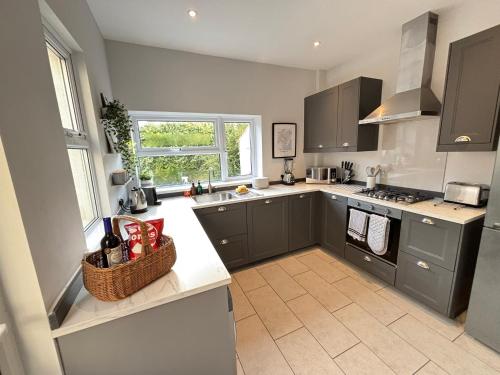 a kitchen with gray cabinets and a counter top at TAFFS MEAD HOUSE Central City Location, nr Stadium, Family Friendly! in Cardiff