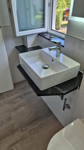 a bathroom with a white sink and a window at PONTUS Ferienwohnung FeWo2 in Zislow