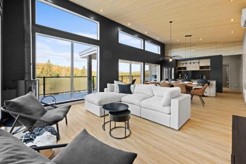 a living room with a white couch and chairs at Spa & Panoramic Nature Views - Alto in Saint Come