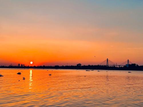 a sunset over a body of water with a bridge at Cồn Phụng Retreats Mekong - Nature Island with Free Boat Shuttle & Fishing in Ben Tre