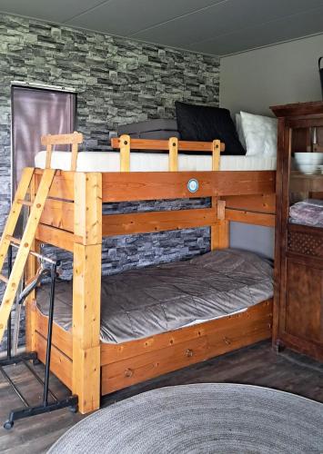 a wooden bunk bed with a ladder in a room at Studio Rozenbottel shared bathroom in Hensbroek