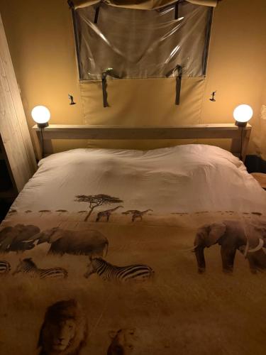 a bed with zebras and other animals on it at The Love Nest in Heelweg