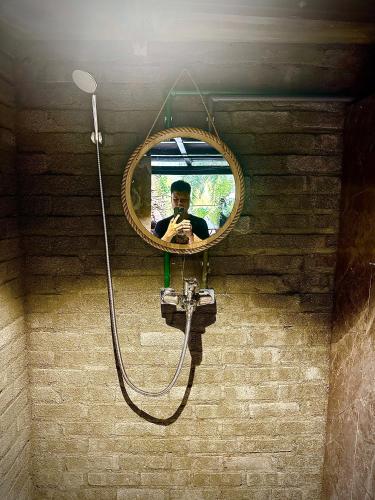 a man taking a picture of himself in a mirror at Loopmoto Riverside Homestay in Làng Lap