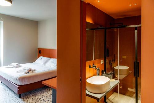 a bedroom with a bed and a shower and a sink at Ghibellini Rooms in Palazzolo Acreide