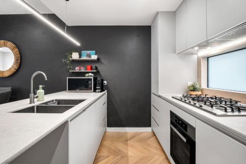 a kitchen with a sink and a stove at Chic Home with BBQ & Outdoor Dining in Carnegie