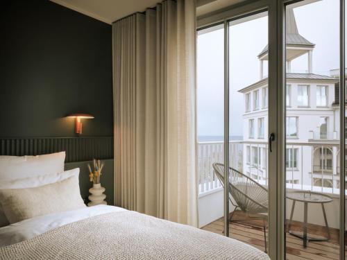a bedroom with a bed and a large window at THE SHORELINE Sellin in Ostseebad Sellin