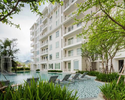 an apartment building with chairs and a swimming pool at 2 Bedroom Summer Huahin Condominium in Hua Hin