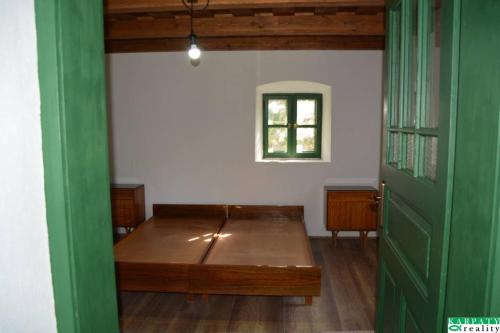 a room with a wooden table and a green door at Chalúpka na Podkylave in Podkylava