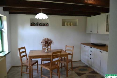 a kitchen with a wooden table and chairs in a room at Chalúpka na Podkylave in Podkylava