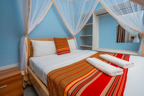 a bedroom with a large bed with a window at SILVER OAKS HOTEL Boma in Fort Portal