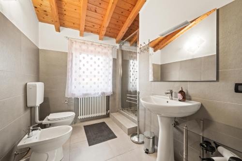a bathroom with a sink and a toilet and a mirror at Villa Luna Appartements und Spa in Calmasino