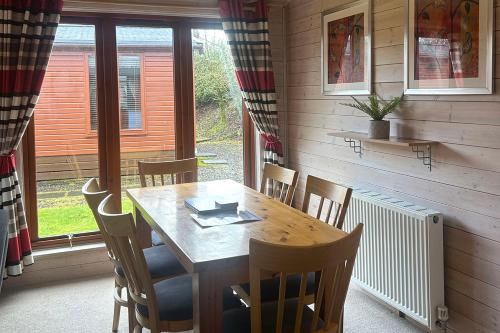 a dining room with a wooden table and chairs at Lomond Woods Holiday Park in Balloch