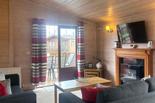 a living room with a couch and a fireplace at Lomond Woods Holiday Park in Balloch