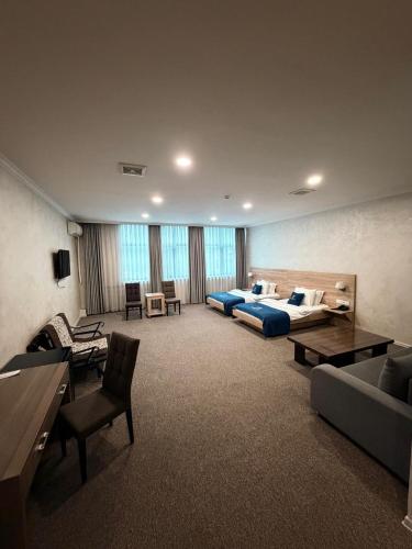 a large living room with two beds and a couch at Janblue Hotel in Almaty