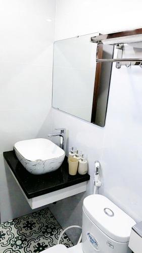 a bathroom with a sink and a toilet and a mirror at Tam Cốc Diện Hoa Hotel & Restaurant in Văn Lâm