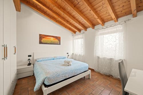 a bedroom with a bed with a teddy bear on it at Villa Luna Appartements und Spa in Calmasino