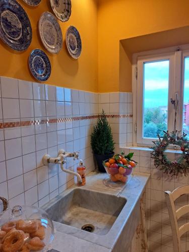 a kitchen with a sink and plates on the wall at La Dimora di Luca in Bientina