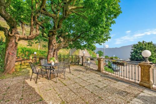 a patio with a table and chairs under a tree at Rooms in Villa Agra in Agra