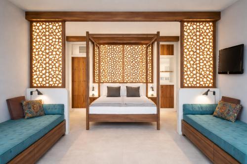 a bedroom with a bed and two couches at Eco Resort WildLand - Zanzibar in Bwejuu