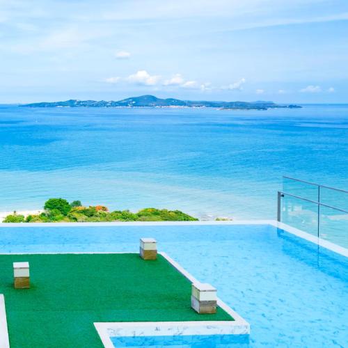 a swimming pool with a view of the ocean at Andromeda Condominium Pattaya in Pattaya South