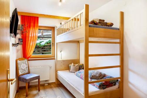a small bedroom with a bunk bed and a ladder at Aparthotel Sonnblick in Kartitsch