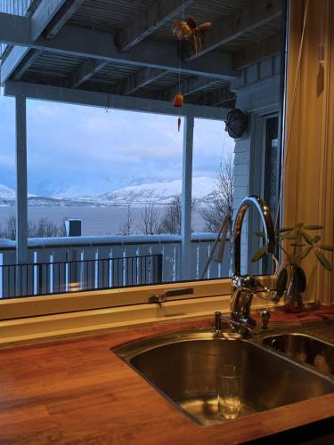 a kitchen with a sink and a window with a view at Exclusive Northernlight villa at Sørtromsøya in Tromsø