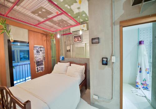 ein Schlafzimmer mit einem weißen Bett und einem Balkon in der Unterkunft Jasaen Hotel in Godown