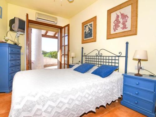 a bedroom with a bed with blue cabinets and a tv at Casa Socias in Comarruga
