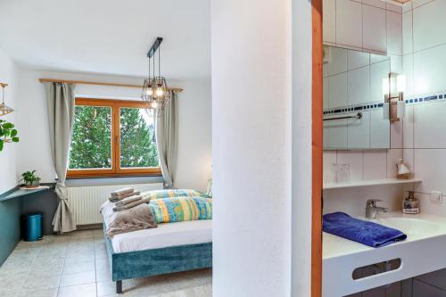 a bedroom with a bed and a sink and a window at Aparthotel Sonnblick in Kartitsch