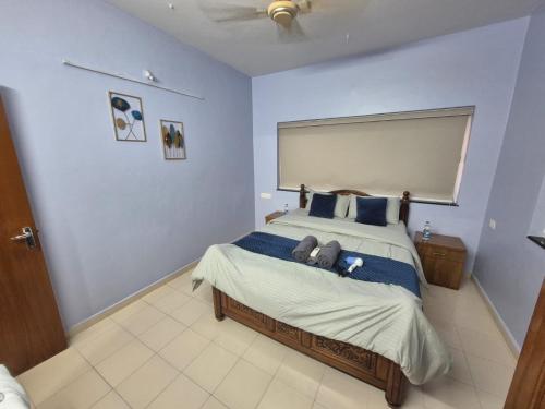 a bedroom with a large bed with blue walls at Bliss Inn in Benaulim