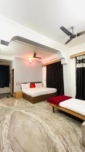 a bedroom with two beds and a ceiling at Hotel Ramya Palace in Gwalior