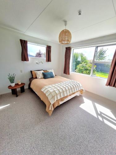 a bedroom with a bed and a large window at 3 bedroom hidden gem in Gore